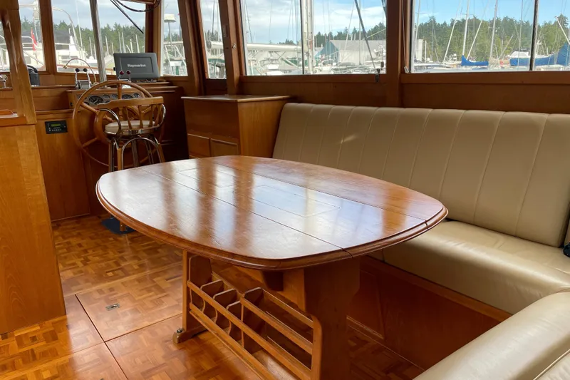 Mercator Yacht Photos Pics Interior of 1985 Grand Banks 42 Classic yacht with wooden table and beige seating.