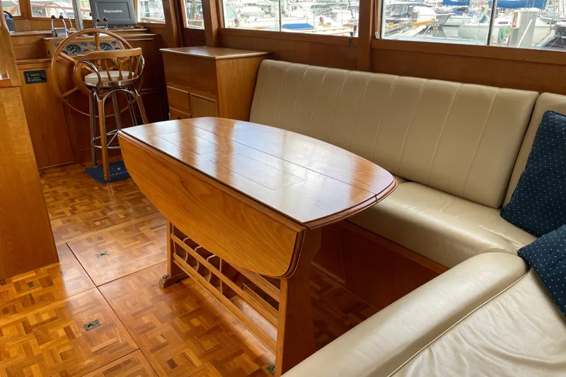 Mercator Yacht Photos Pics Interior of 1985 Grand Banks 42 Classic yacht with wooden table and beige seating.