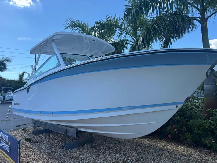  Yacht Photos Pics 2026 Blackfin 272 DC boat displayed outdoors with palm trees in the background.
