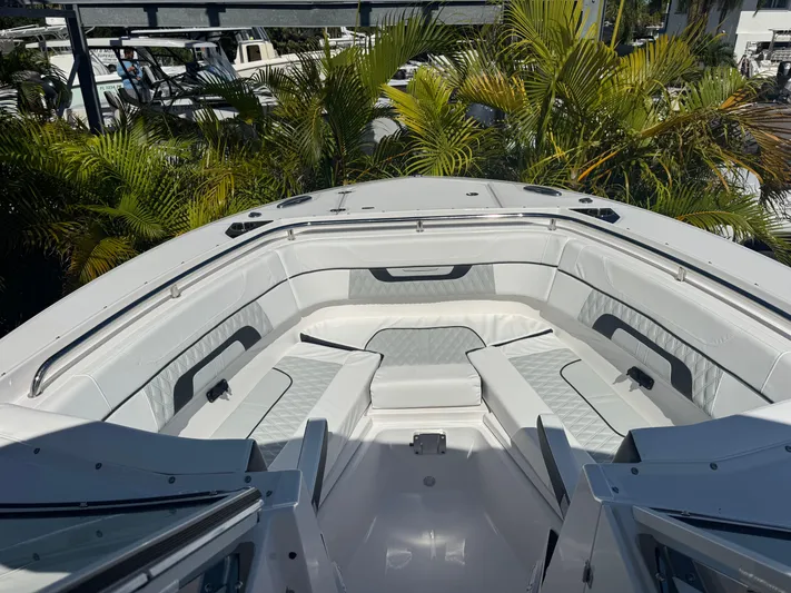  Yacht Photos Pics 2026 Blackfin 272 DC boat interior with white seating and lush greenery background.