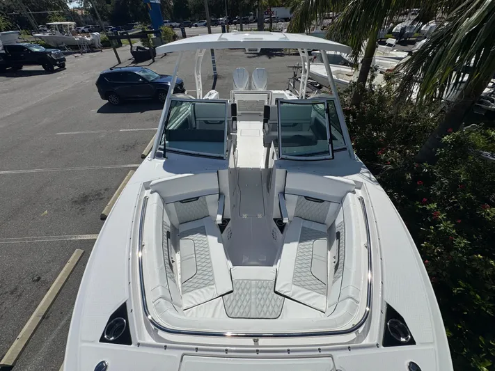  Yacht Photos Pics 2026 Blackfin 272 DC boat with spacious seating, parked in a sunny lot.