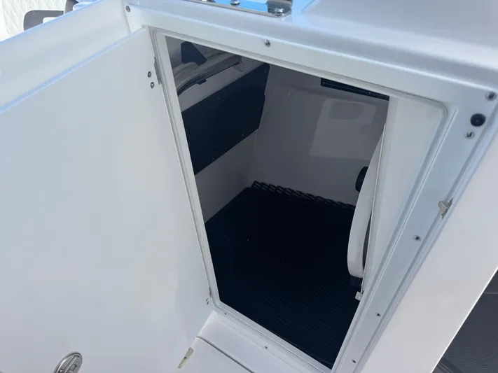  Yacht Photos Pics 2026 Blackfin 272 DC boat interior storage compartment with open door.