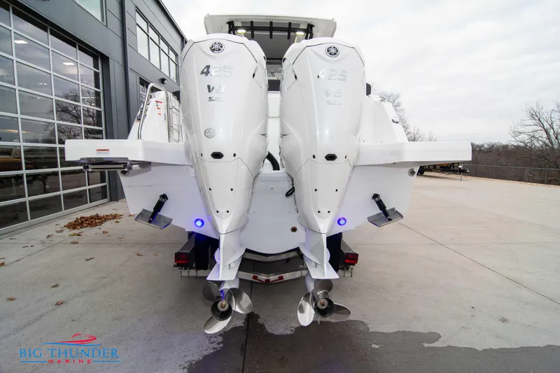  Yacht Photos Pics 2023 Jeanneau Leader 10.5 CC with twin outboard engines, parked outdoors.