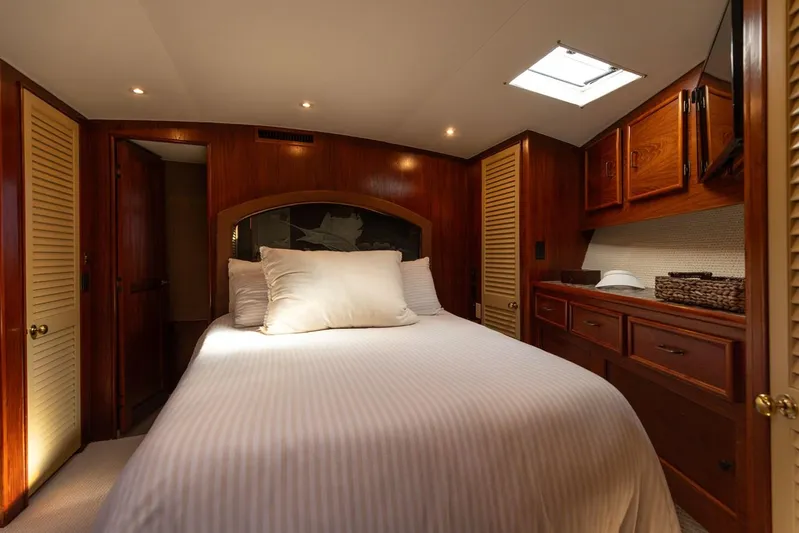 Lucky Marlin Yacht Photos Pics Luxurious bedroom interior of 1987 Ocean Yachts Convertible, featuring wood paneling and cozy bedding.