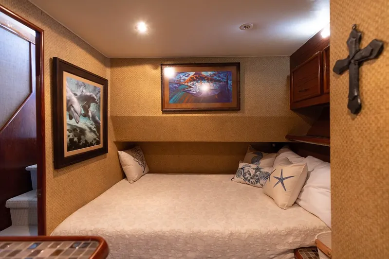 Lucky Marlin Yacht Photos Pics Cozy bedroom in 1987 Ocean Yachts Convertible, featuring nautical decor and artwork.