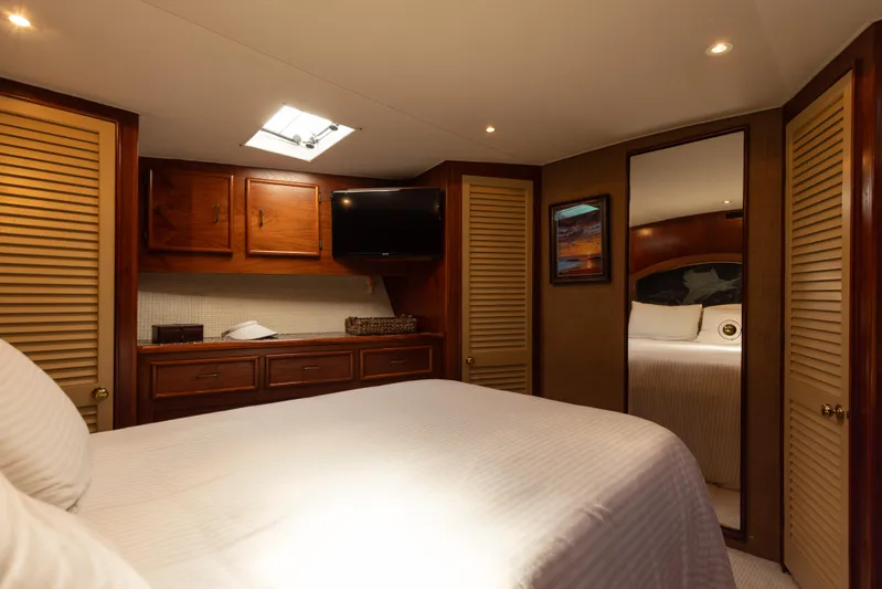 Lucky Marlin Yacht Photos Pics Luxurious cabin interior of a 1987 Ocean Yachts Convertible, featuring wood accents and cozy bedding.