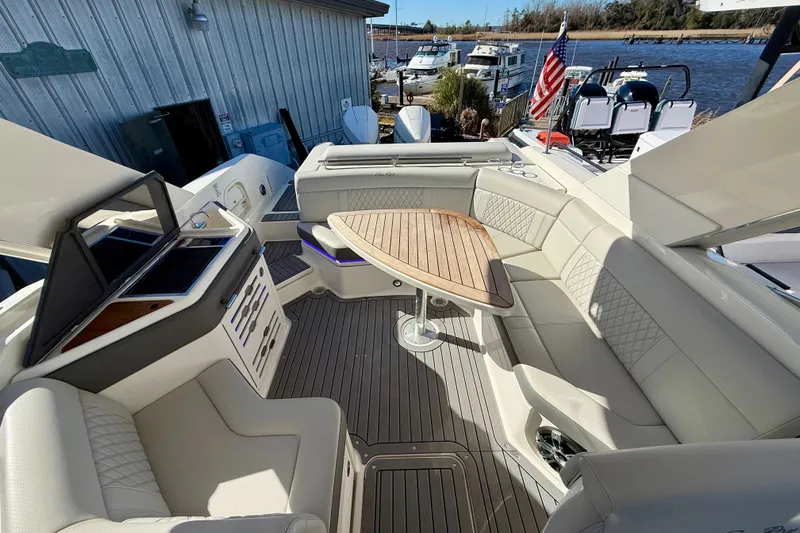  Yacht Photos Pics 2021 Sea Ray SLX 310 Outboard boat interior with luxurious seating and wooden table.