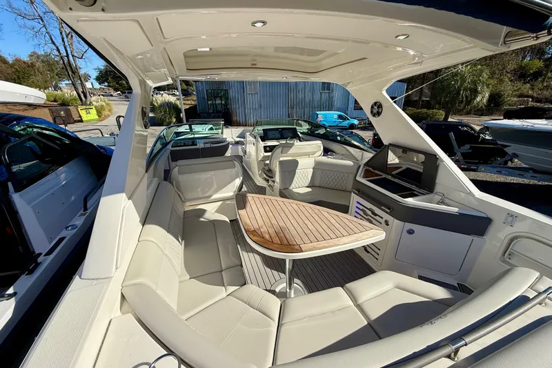  Yacht Photos Pics 2021 Sea Ray SLX 310 Outboard interior with luxurious seating and wooden table.