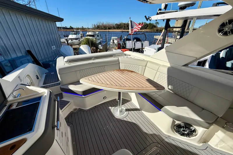  Yacht Photos Pics Luxurious 2021 Sea Ray SLX 310 Outboard boat interior with seating and table, docked by the water.