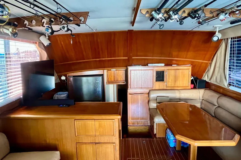 Precision Fisher Yacht Photos Pics 1988 Post 46 Sportfish interior with wood cabinetry, seating, and fishing rods.