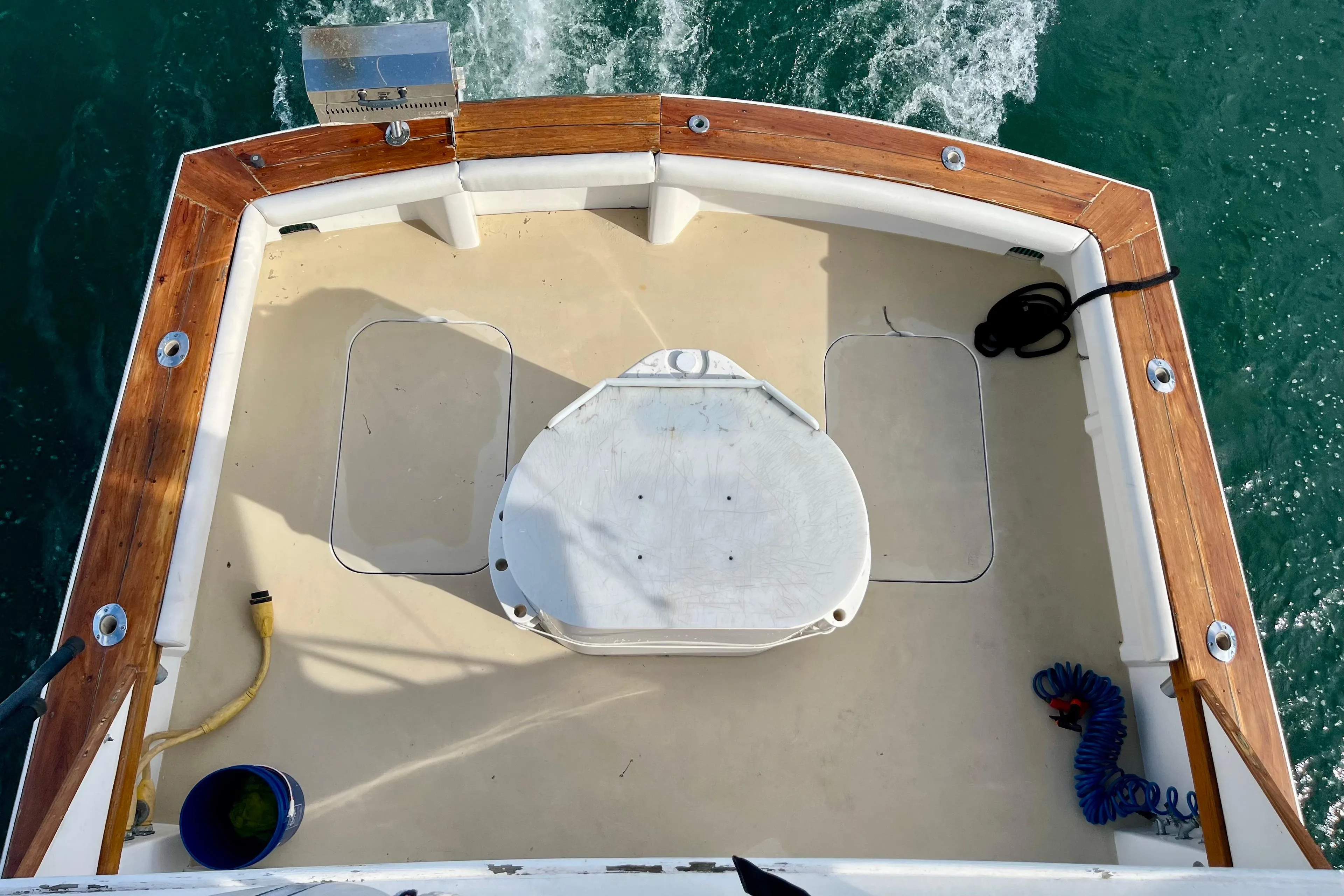 1988 Post 46 Sportfish boat deck with fishing chair, wooden trim, and ocean backdrop.