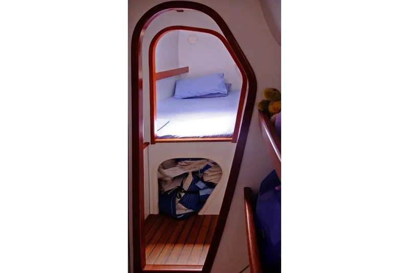 Delphine Yacht Photos Pics Cozy cabin interior of 2003 Outremer 45 sailboat with wooden accents and storage space.