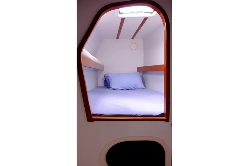 Delphine Yacht Photos Pics Cozy cabin interior of 2003 Outremer 45 sailboat with blue bedding.