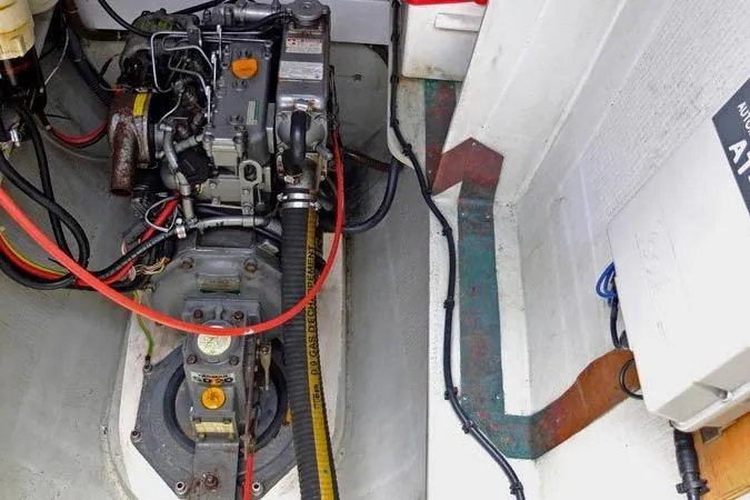 Delphine Yacht Photos Pics Engine compartment of a 2003 Outremer 45 catamaran, showcasing mechanical components and wiring.