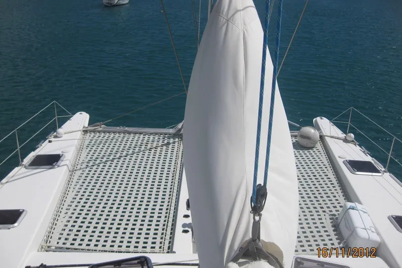 Delphine Yacht Photos Pics Outremer 45 catamaran deck view, 2003 model, anchored on calm blue water.