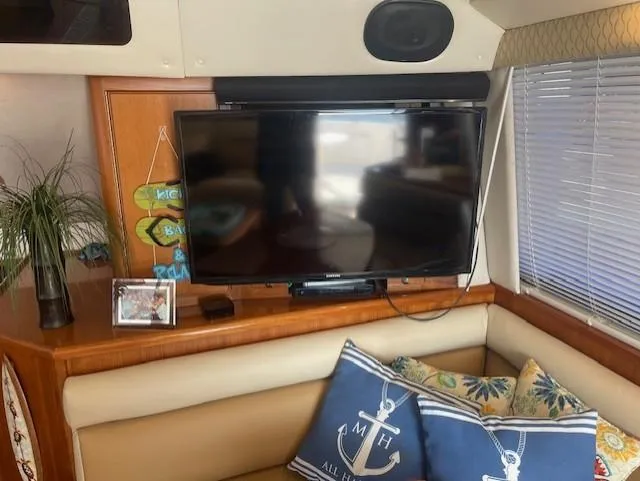 All Hans In Yacht Photos Pics 1999 Riviera SF interior with TV, nautical-themed pillows, and decorative plants.