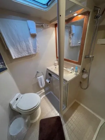 All Hans In Yacht Photos Pics Compact bathroom in 1999 Riviera SF yacht with shower, toilet, and sink.