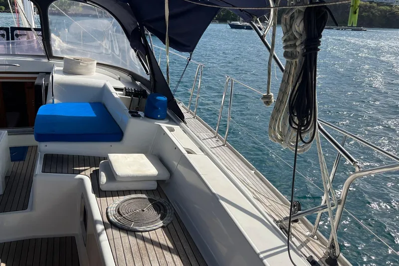 Saba Yacht Photos Pics 2013 Jeanneau 57 sailboat deck with blue cushions and coiled ropes, overlooking the sea.