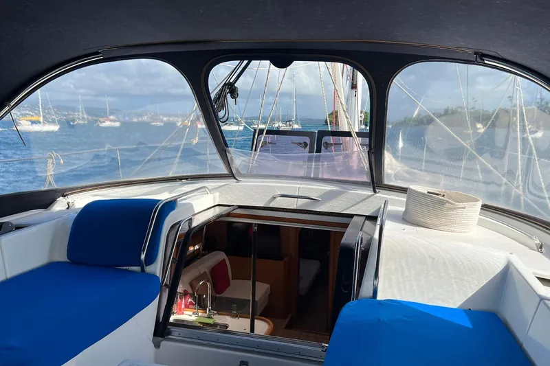Saba Yacht Photos Pics 2013 Jeanneau 57 yacht interior with blue seating, overlooking a scenic harbor view.