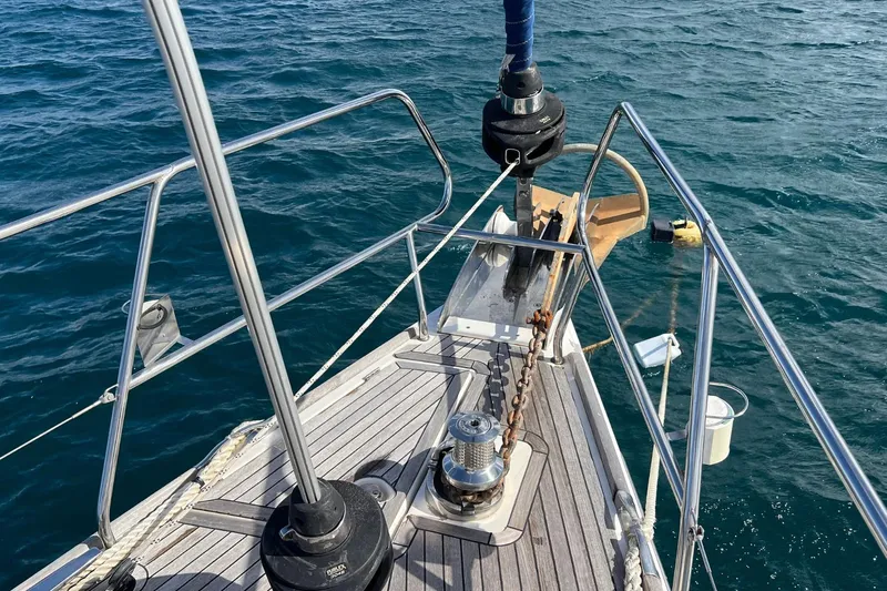 Saba Yacht Photos Pics Bow of 2013 Jeanneau 57 yacht with anchor chain, on calm sea.