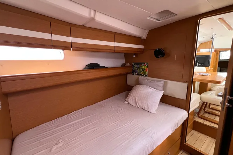 Saba Yacht Photos Pics Interior cabin of 2013 Jeanneau 57 yacht with cozy bed and wooden furnishings.