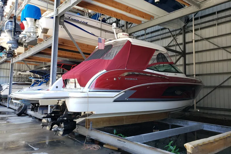 Ship Faced Yacht Photos Pics 2015 Formula 350 Crossover Bowrider in storage, red cover, American flag displayed.