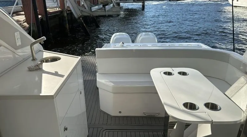 Seas The Moment Yacht Photos Pics Luxury Evolve 400HT yacht deck with seating and table, 2021 model, docked by the water.