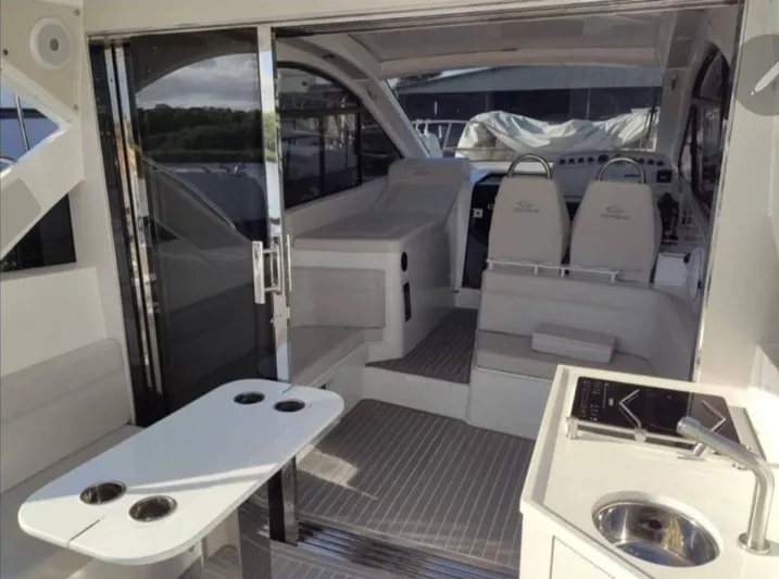 Seas The Moment Yacht Photos Pics 2021 Evolve 400HT yacht interior with modern seating and sleek design.