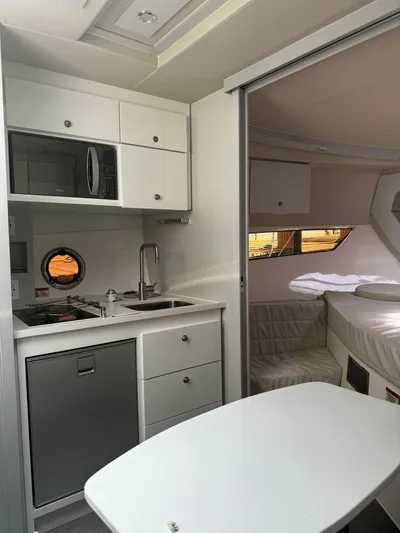 Seas The Moment Yacht Photos Pics Interior of 2021 Evolve 400HT yacht with kitchenette and cozy sleeping area.