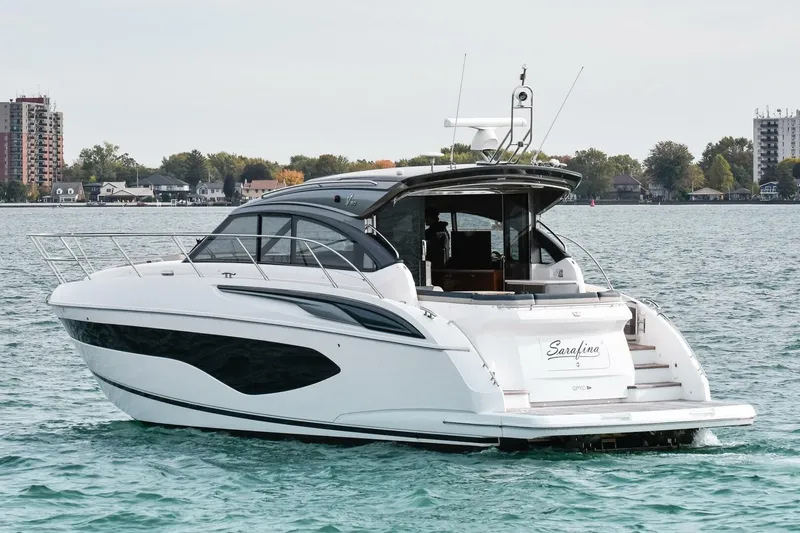  Yacht Photos Pics 2022 Princess V50 yacht cruising on a serene lake with a cityscape backdrop.