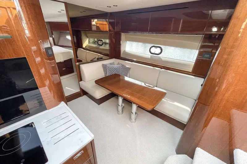  Yacht Photos Pics Luxurious interior of 2022 Princess V50 yacht with elegant wood finishes and cozy seating area.