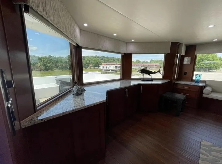  Yacht Photos Pics Interior of a 2015 Stardust Cruisers 20' x 106' houseboat with large windows and wooden cabinetry.
