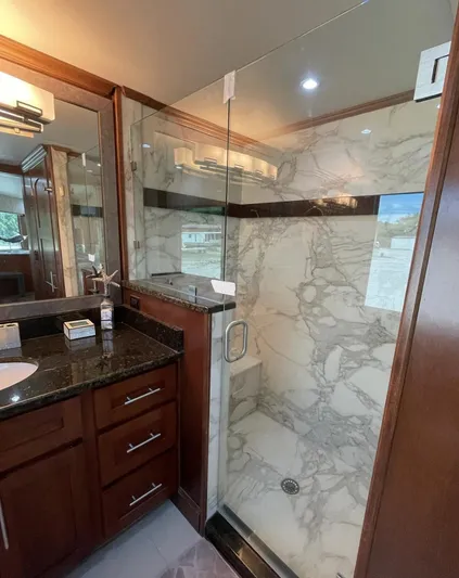  Yacht Photos Pics Luxurious bathroom in 2015 Stardust Cruisers houseboat with marble shower and wooden cabinetry.