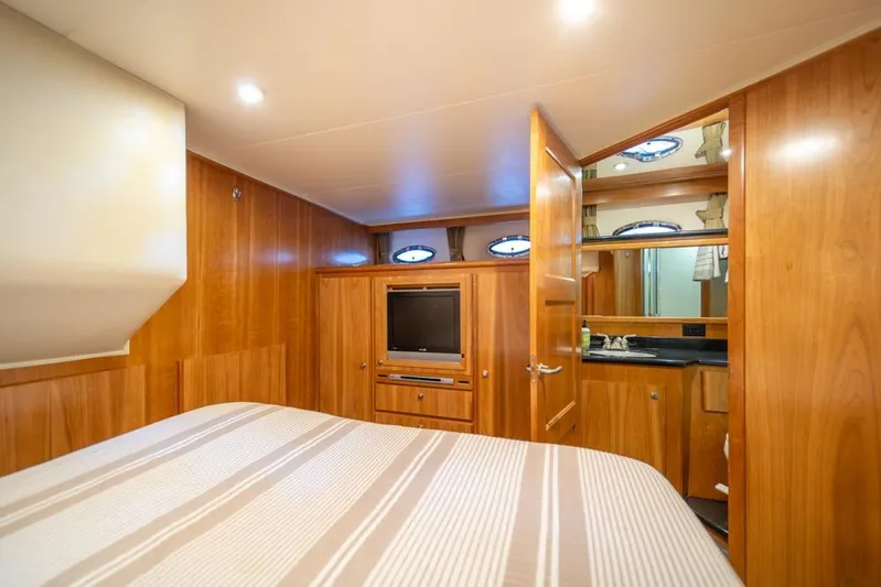 Restless II Yacht Photos Pics Luxurious 2007 Navigator Classic 48 yacht bedroom with wood paneling and ensuite bathroom.