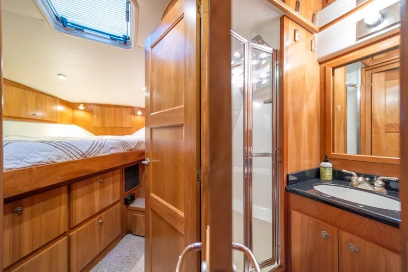 Restless II Yacht Photos Pics Luxurious 2007 Navigator Classic 48 yacht interior with wood finish, featuring a cozy bedroom and bathroom.