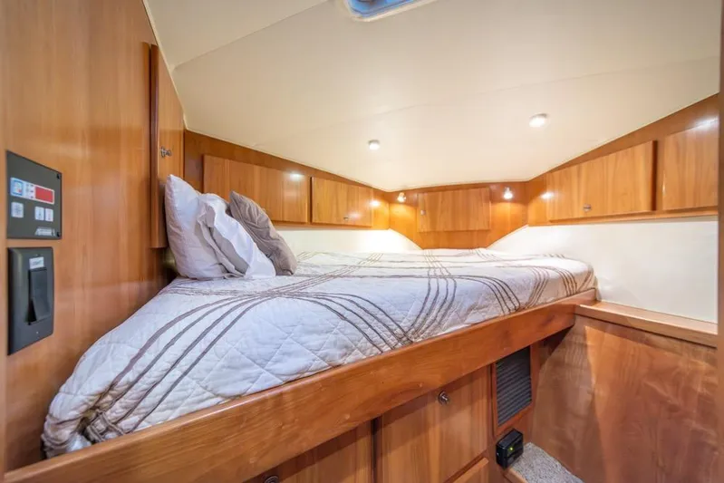 Restless II Yacht Photos Pics Cozy cabin interior of 2007 Navigator Classic 48 yacht with wooden finish and comfortable bedding.