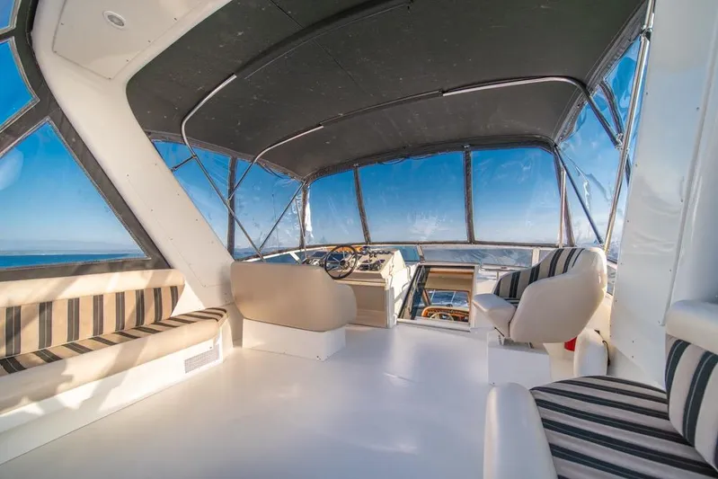 Restless II Yacht Photos Pics Interior of 2007 Navigator Classic 48 yacht with striped seating and panoramic windows.