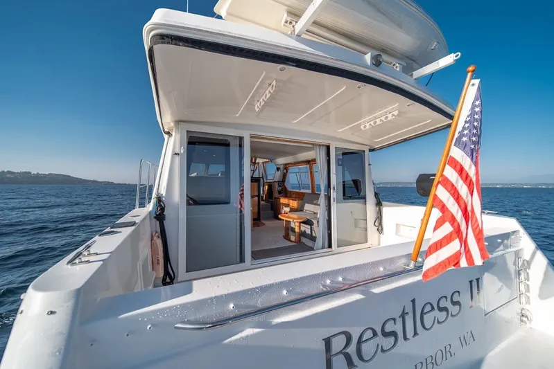 Restless II Yacht Photos Pics 2007 Navigator Classic 48 yacht with American flag, open cabin, and ocean view.