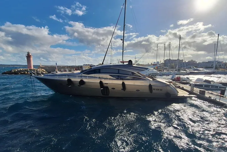  Yacht Photos Pics 2008 Pershing 72 yacht docked in a sunny marina with a lighthouse in the background.