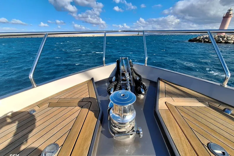  Yacht Photos Pics Bow view of 2008 Pershing 72 yacht with wooden deck and ocean backdrop.