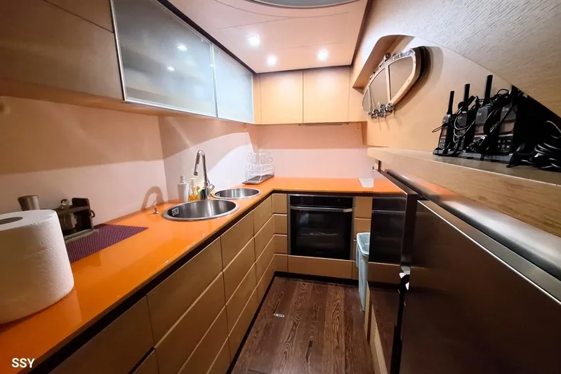  Yacht Photos Pics Modern kitchen interior on a 2008 Pershing 72 yacht, featuring sleek cabinetry and orange countertops.