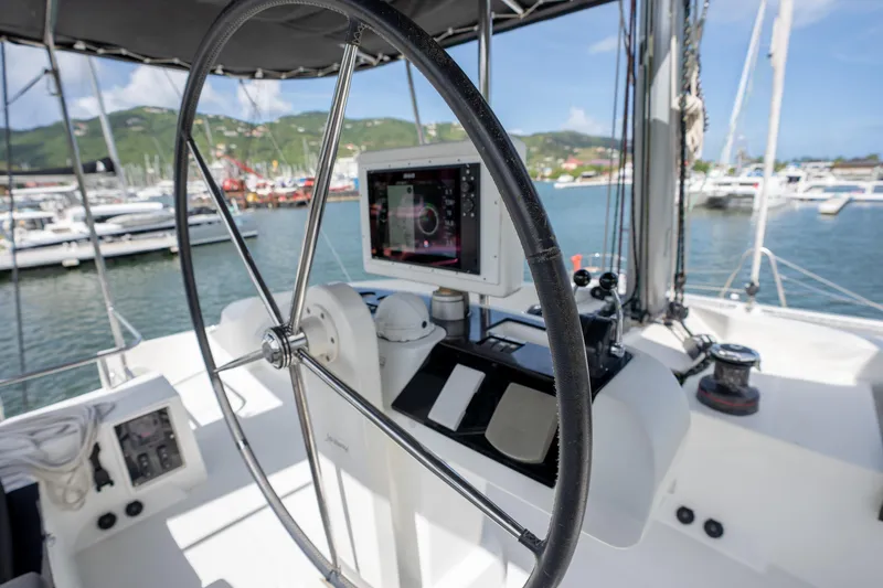 Blue Octane Yacht Photos Pics Steering wheel and controls of a 2018 Lagoon 52 F yacht in a marina.