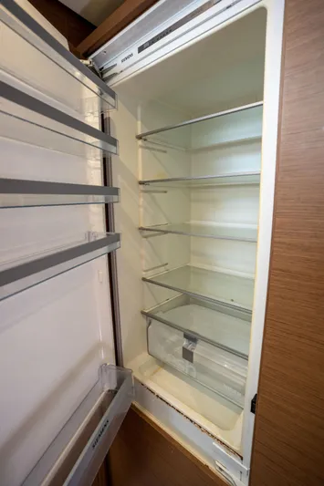 Blue Octane Yacht Photos Pics Empty refrigerator inside 2018 Lagoon 52 F yacht, featuring multiple shelves and door compartments.