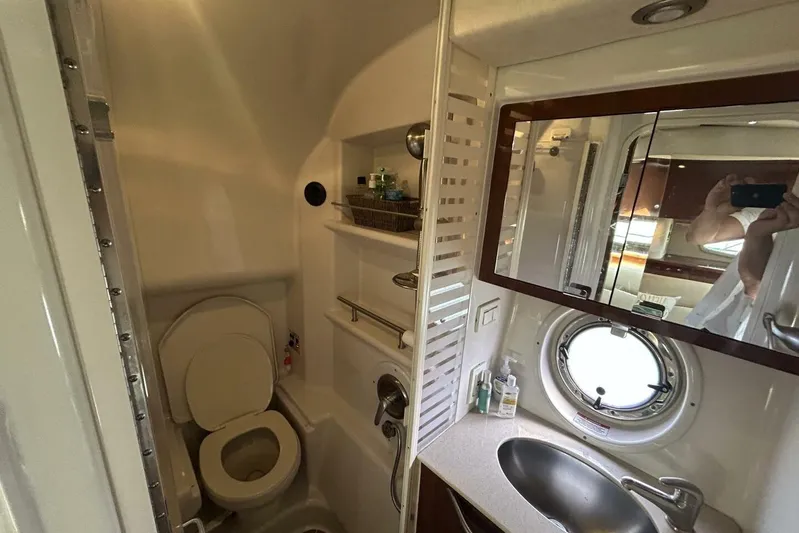  Yacht Photos Pics Bathroom interior of 2010 Sea Ray 370 Sundancer yacht, featuring sink, toilet, and porthole window.
