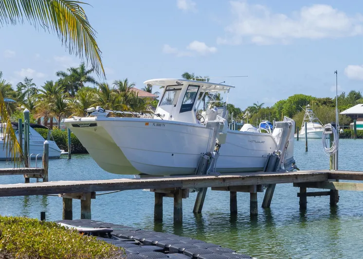  Yacht Photos Pics 2024 World Cat 260CC boat docked in a tropical marina setting.