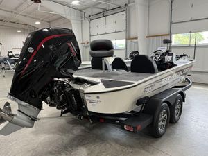2025 Tracker Savage 215 boat in showroom, featuring powerful outboard motor and dual-axle trailer.