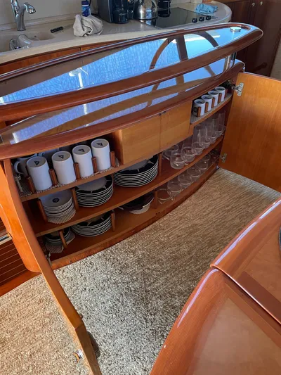 Mercia Yacht Photos Pics Interior of 2002 Azimut 55 Flybridge yacht with elegant wooden cabinetry and organized dishware.
