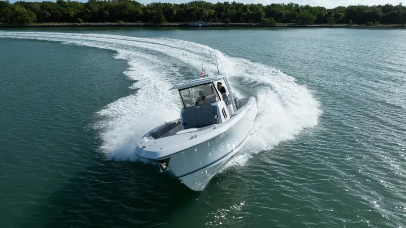  Yacht Photos Pics 2018 Belzona 325 Center Console boat cruising on a serene lake.