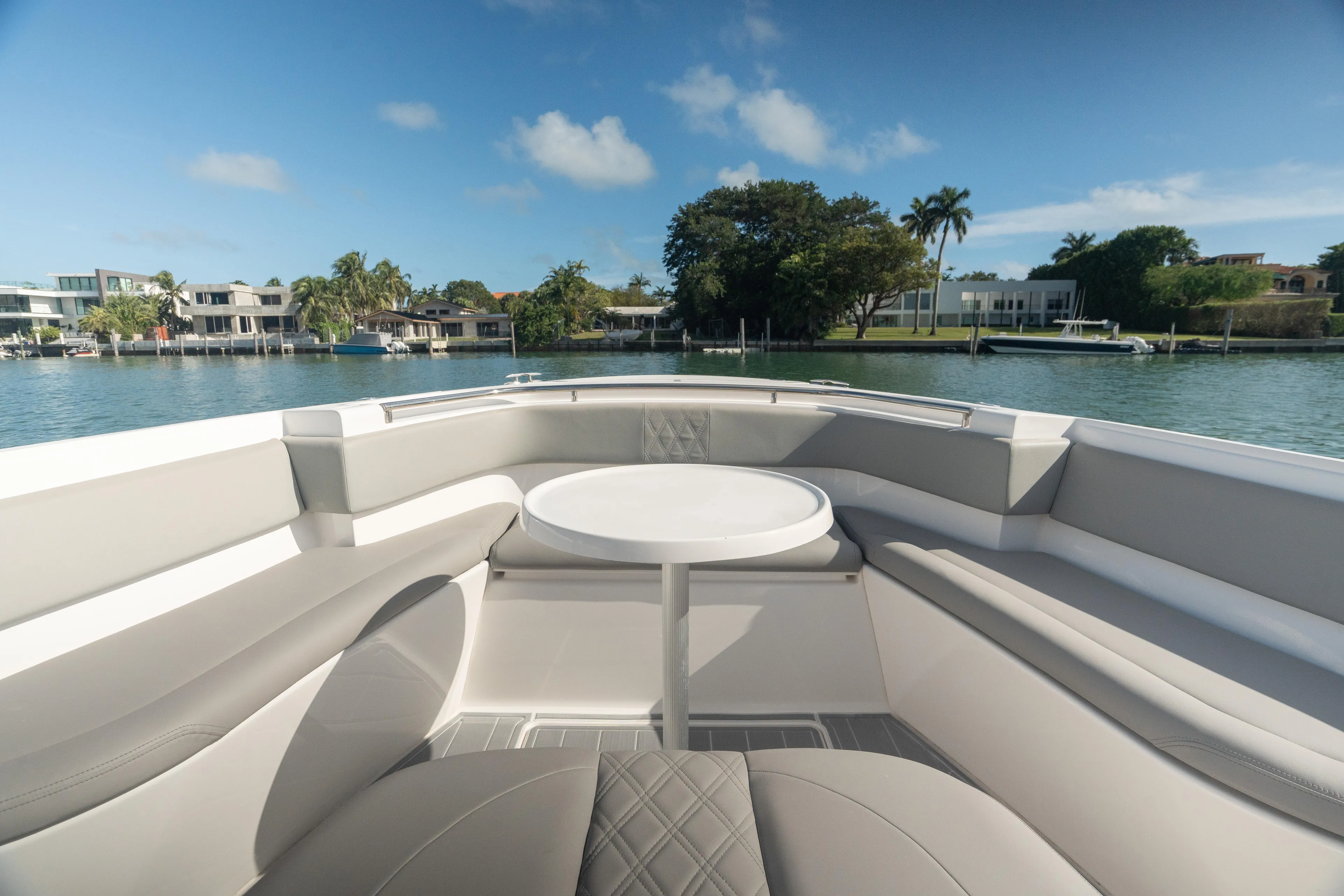  Yacht Photos Pics 2018 Belzona 325 Center Console boat interior with seating and table, overlooking waterfront homes.