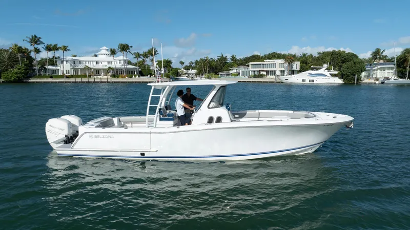  Yacht Photos Pics 2018 Belzona 325 Center Console boat cruising on a sunny day near luxury waterfront homes.